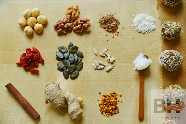 a selection of ingredients is laid out in a rough grid pattern: chickpeas, walnuts, salt, sunflowr seeds, pumpkin seeds, cinnamon, ginger, coconut oil, and others